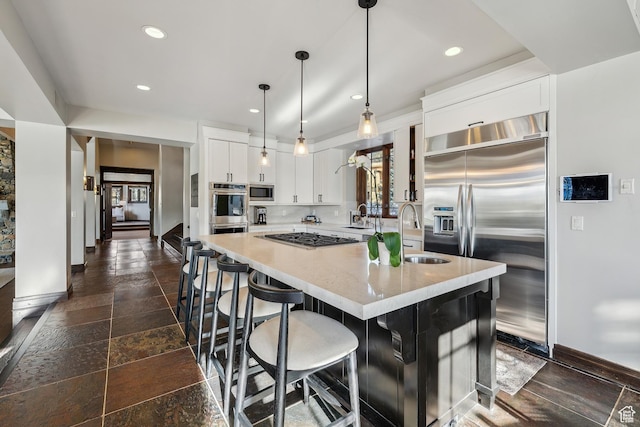 9255 Par Ct, Park City, UT 84098 - kitchen featuring stone tile floors, a kitchen island with sink, a sink, built in appliances, and white cabinetry