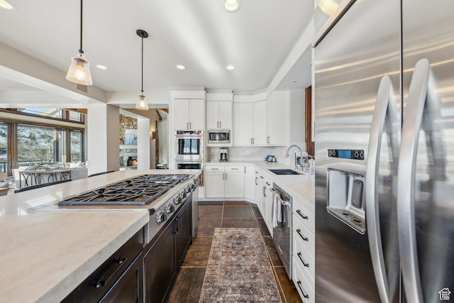 9255 Par Ct, Park City, UT 84098 - kitchen with backsplash, pendant lighting, appliances with stainless steel finishes, white cabinetry, and a sink