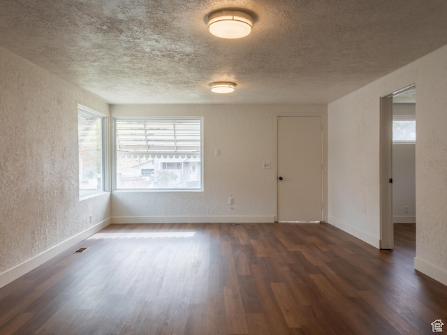 735 Castle Gate Rd, Helper, UT 84526 - spare room with visible vents, a textured wall, dark wood-type flooring, a textured ceiling, and baseboards