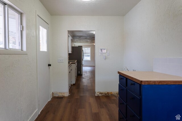 735 Castle Gate Rd, Helper, UT 84526 - corridor with a textured wall, dark wood-type flooring, visible vents, and baseboards