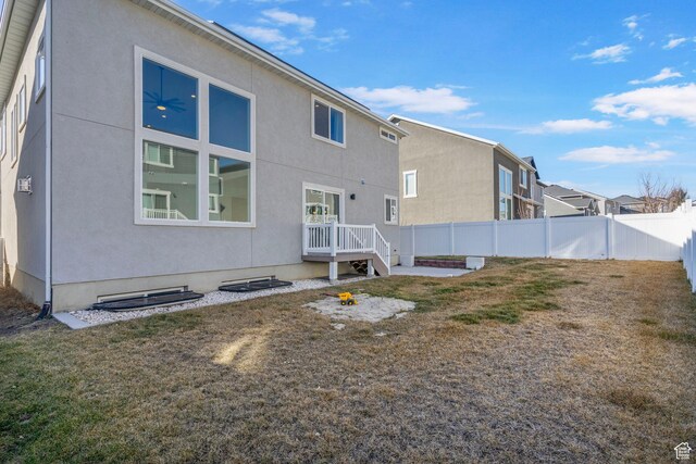 134 N Eden Brook Way, Saratoga Springs, UT 84045 - rear view of house featuring fence private yard, a lawn, and stucco siding