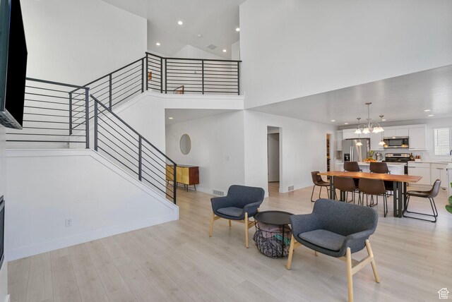 134 N Eden Brook Way, Saratoga Springs, UT 84045 - interior space featuring light wood-type flooring, an inviting chandelier, a high ceiling, and stairway