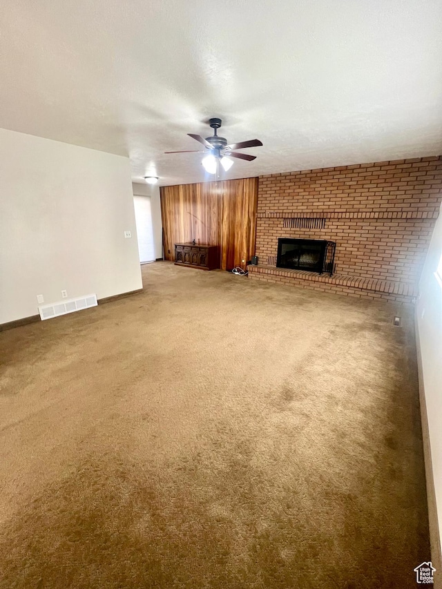 305 N 200 E, Elsinore, UT 84724 - unfurnished living room with carpet floors, a brick fireplace, visible vents, and a ceiling fan