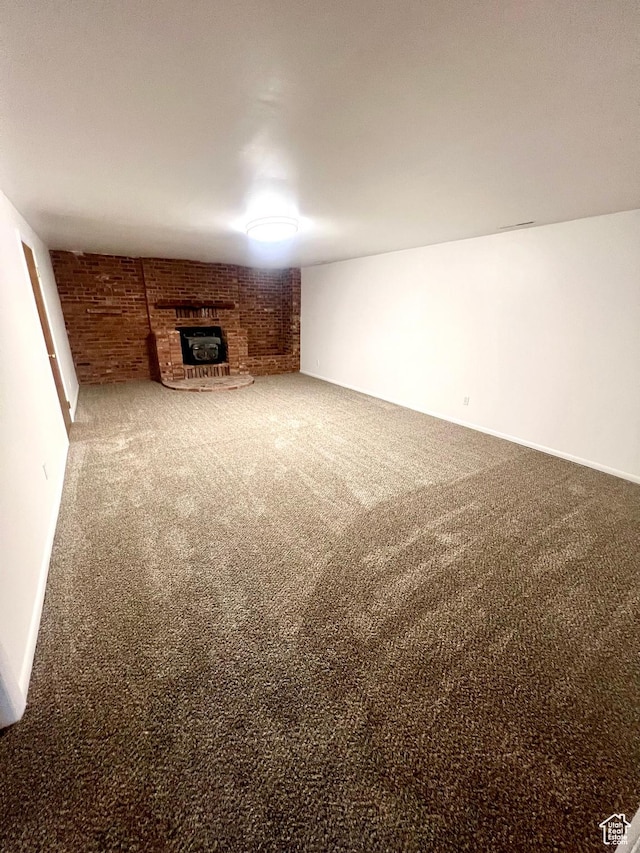 305 N 200 E, Elsinore, UT 84724 - unfurnished living room with brick wall, a fireplace, carpet flooring, and baseboards