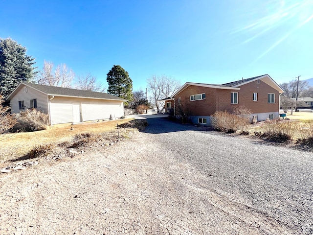 305 N 200 E, Elsinore, UT 84724 - view of home's exterior with gravel driveway, brick siding, and an outbuilding