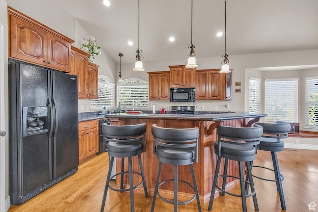 990 W Adams Cir, Bluffdale, UT 84065 - kitchen with light wood finished floors, dark countertops, vaulted ceiling, black appliances, and a kitchen breakfast bar