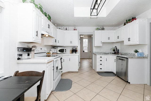 kitchen with white cabinets, tasteful backsplash, white appliances, under cabinet range hood, and light tile patterned floors