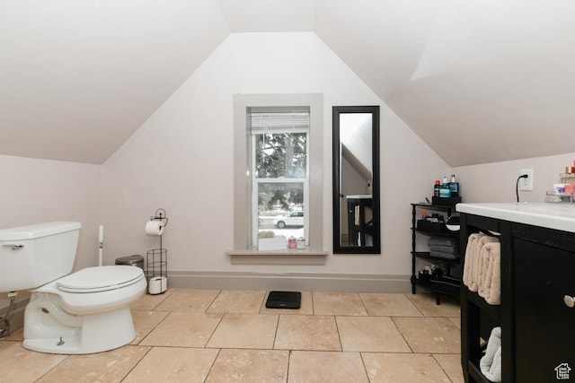 bathroom featuring lofted ceiling, baseboards, vanity, and toilet