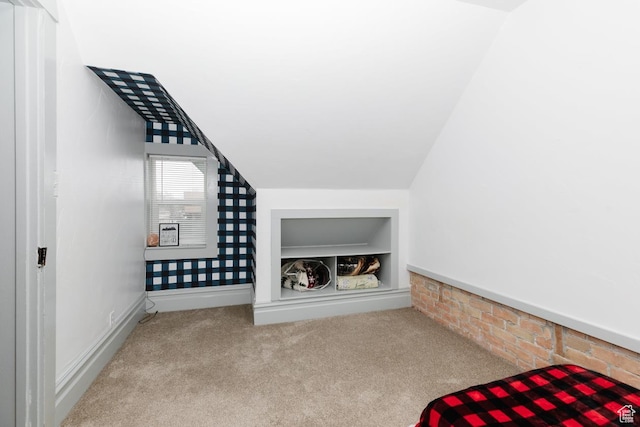 bonus room featuring baseboards, vaulted ceiling, carpet flooring, and built in features