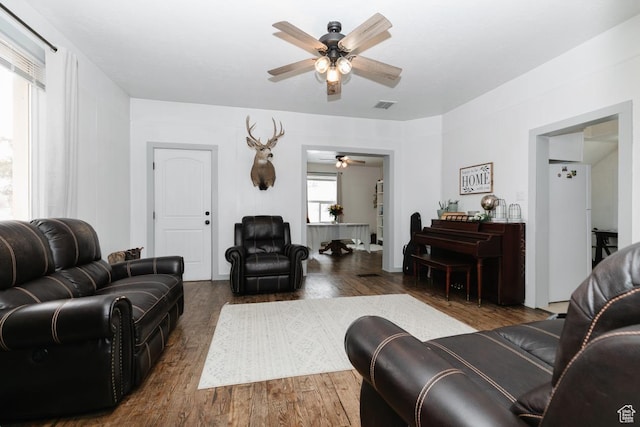 living area with a ceiling fan, wood finished floors, and visible vents