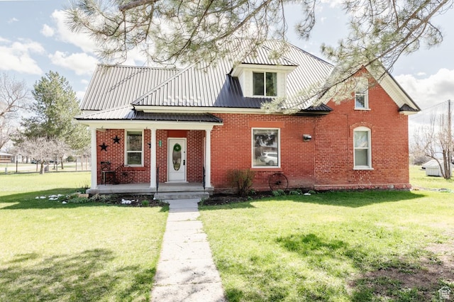 view of front of house featuring brick siding, a porch, a front yard, and metal roof