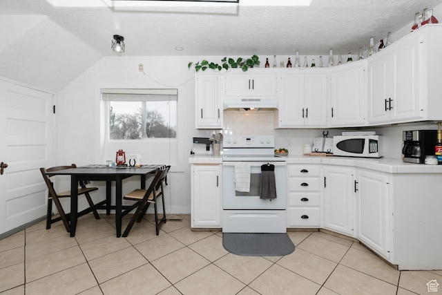 kitchen featuring vaulted ceiling, white cabinetry, white appliances, under cabinet range hood, and tile countertops