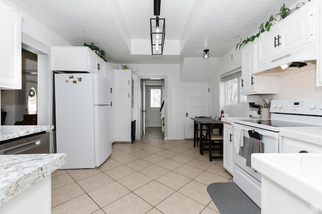 kitchen with white cabinets, a textured ceiling, under cabinet range hood, and white appliances