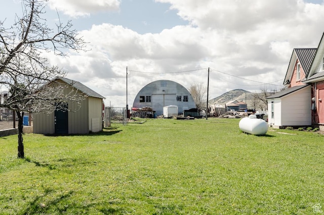 view of yard with an outdoor structure, a storage shed, and a mountain view