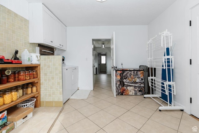 clothes washing area with washer and dryer, laundry area, and light tile patterned floors