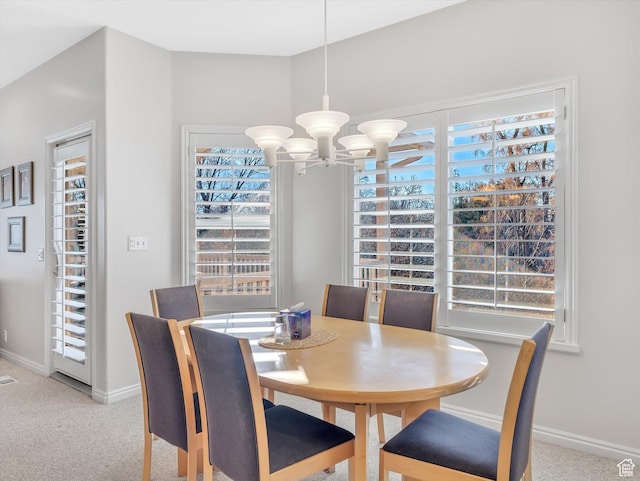 dining space featuring baseboards, carpet, and a notable chandelier