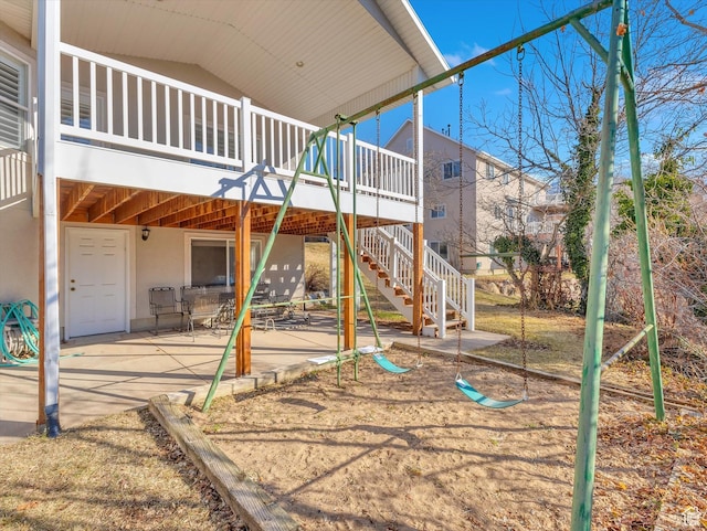 view of play area featuring a patio area, stairway, and a wooden deck