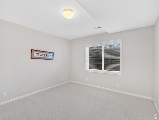 carpeted empty room with visible vents and baseboards