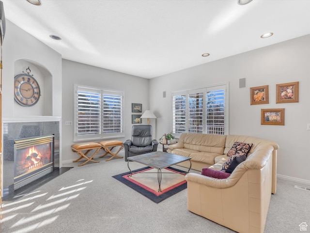 carpeted living room with recessed lighting, a tile fireplace, visible vents, and baseboards