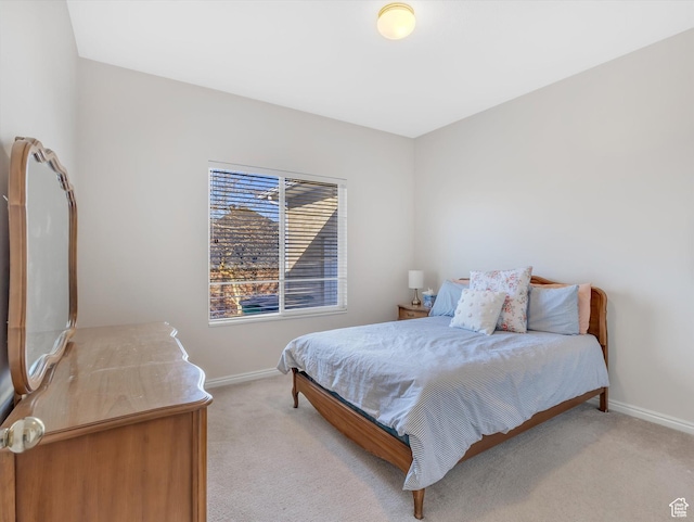 bedroom featuring baseboards and light colored carpet