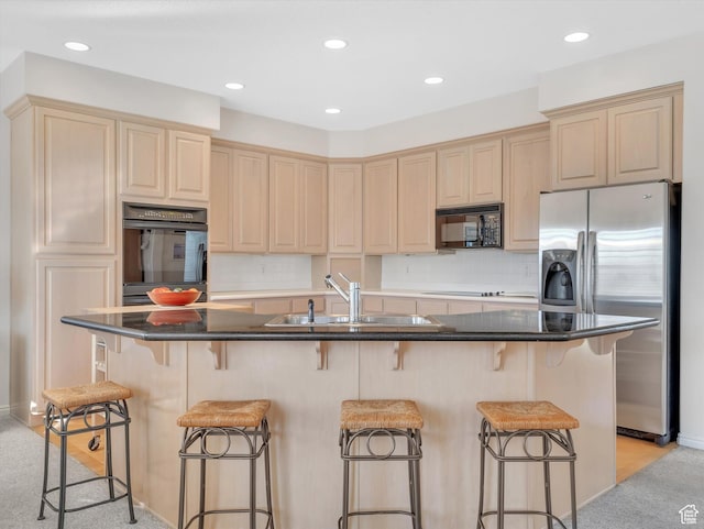 kitchen featuring decorative backsplash, light brown cabinets, a sink, and black appliances