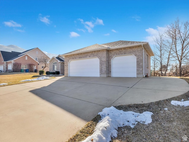 view of front of house featuring a garage, driveway, brick siding, and roof with shingles