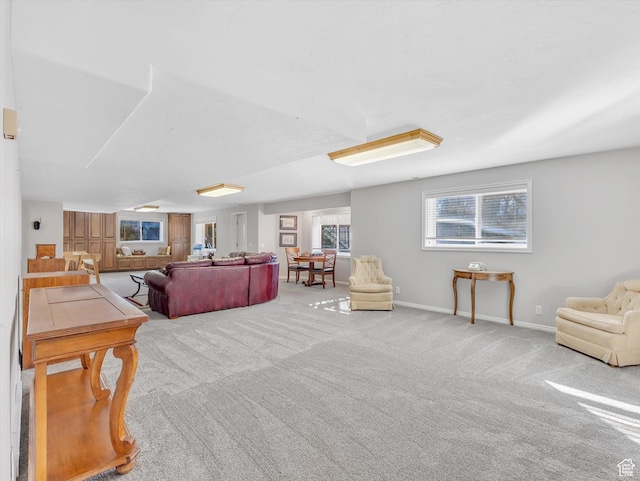 carpeted living area featuring baseboards