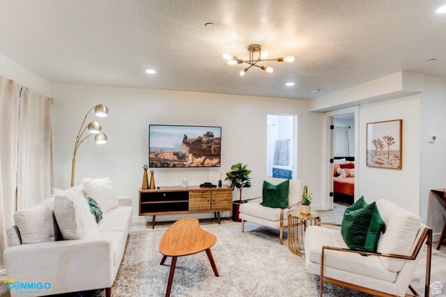 living area with recessed lighting, a notable chandelier, and a textured ceiling