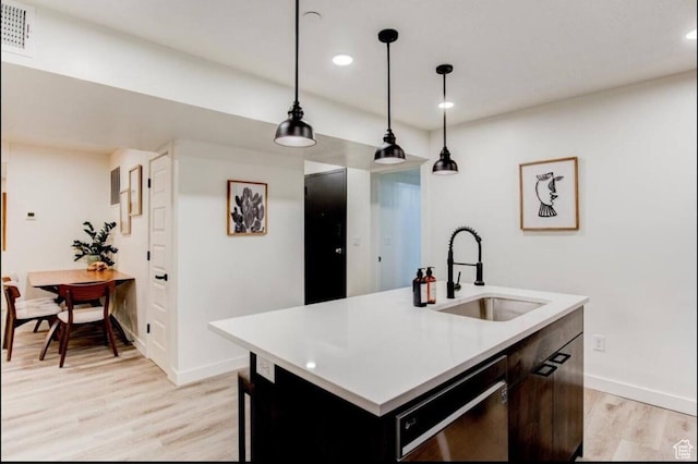 kitchen featuring a sink, visible vents, light countertops, light wood-type flooring, and dishwasher