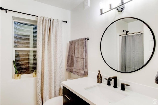 full bath featuring toilet, a shower with shower curtain, and vanity