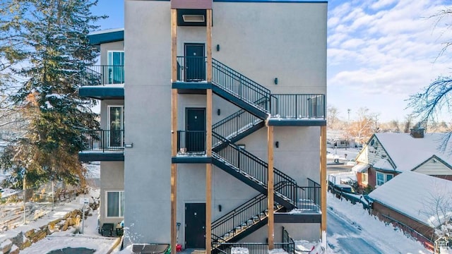 snow covered property with stairs