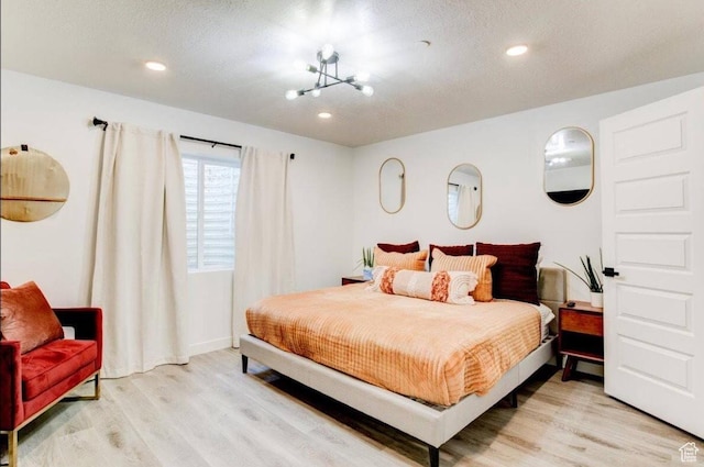 bedroom with light wood-style floors and recessed lighting