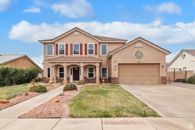 187 N Stone Mountain Dr, St George, UT 84770 - view of front facade featuring stucco siding, stone siding, an attached garage, driveway, and a front lawn
