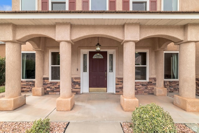 187 N Stone Mountain Dr, St George, UT 84770 - doorway to property featuring stone siding, a porch, and stucco siding
