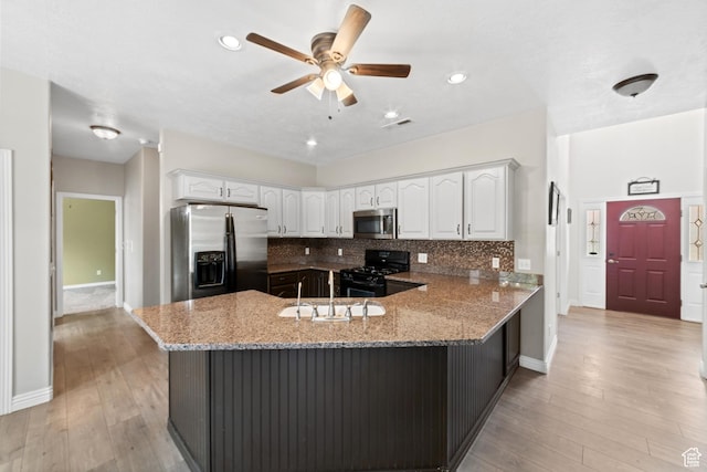 187 N Stone Mountain Dr, St George, UT 84770 - kitchen featuring stainless steel appliances, a peninsula, a sink, light stone counters, and white cabinets
