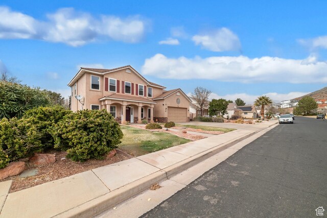 187 N Stone Mountain Dr, St George, UT 84770 - traditional-style house featuring stucco siding, an attached garage, driveway, and a porch