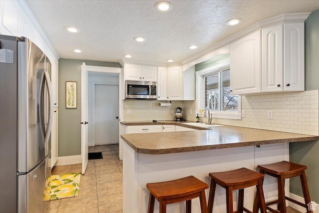 4884 E 2800 N, Eden, UT 84310 - kitchen with a peninsula, appliances with stainless steel finishes, a sink, and white cabinets