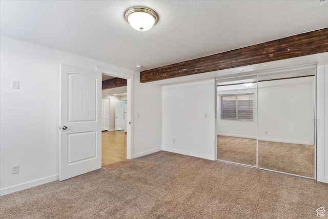 4884 E 2800 N, Eden, UT 84310 - unfurnished bedroom featuring baseboards, carpet, beam ceiling, a textured ceiling, and a closet
