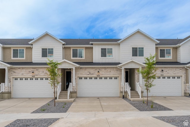 684 W 4500 S Unit 313, Mapleton, UT 84664 - view of property featuring a garage, concrete driveway, board and batten siding, and stone siding