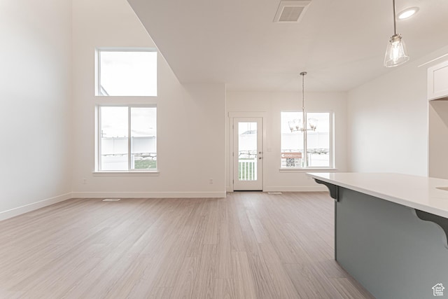 684 W 4500 S Unit 313, Mapleton, UT 84664 - unfurnished living room featuring a chandelier, plenty of natural light, and light wood finished floors