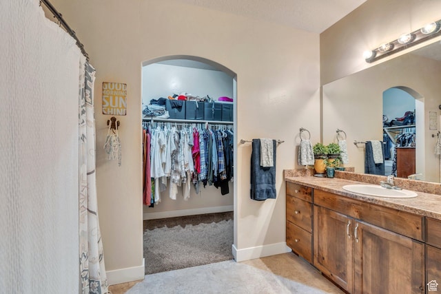 80 Pheasant, Elk Ridge, UT 84651 - bathroom featuring vanity, a walk in closet, baseboards, and tile patterned flooring
