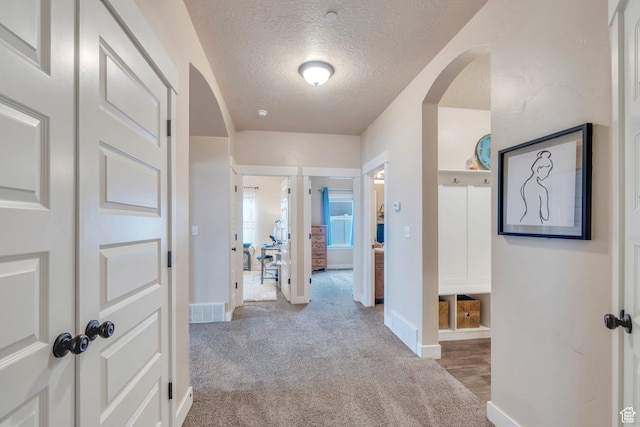80 Pheasant, Elk Ridge, UT 84651 - corridor featuring a textured ceiling, carpet flooring, arched walkways, and baseboards