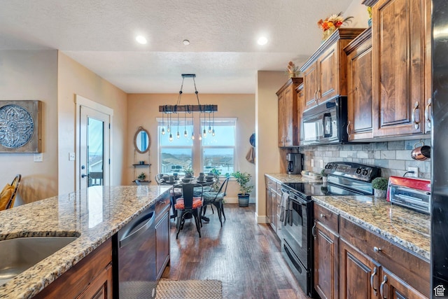 kitchen with tasteful backsplash, black appliances, light stone counters, a textured ceiling, and dark wood-style flooring