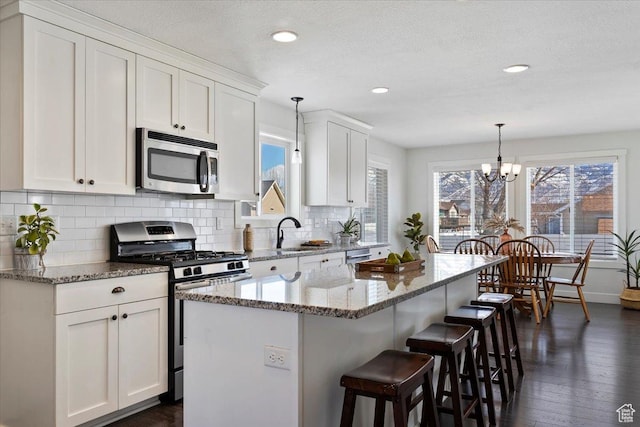 2588 S 1000 W, Nibley, UT 84321 - kitchen featuring stainless steel appliances, a sink, white cabinetry, decorative backsplash, and recessed lighting