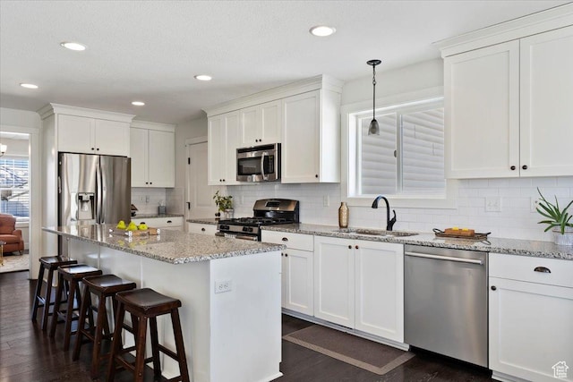 2588 S 1000 W, Nibley, UT 84321 - kitchen featuring stainless steel appliances, a sink, dark wood-style flooring, white cabinets, and a kitchen breakfast bar