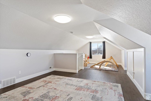 2588 S 1000 W, Nibley, UT 84321 - additional living space with a textured ceiling, dark wood-style floors, baseboards, and vaulted ceiling
