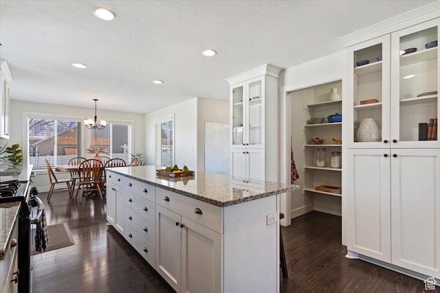 2588 S 1000 W, Nibley, UT 84321 - kitchen featuring a chandelier, stainless steel range with gas stovetop, white cabinets, a center island, and dark wood-style flooring