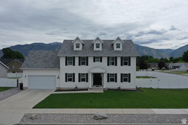 2588 S 1000 W, Nibley, UT 84321 - colonial-style house with a garage, driveway, a mountain view, and a shingled roof