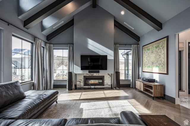 living area with high vaulted ceiling, beam ceiling, a healthy amount of sunlight, and a premium fireplace