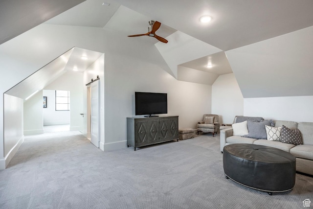 carpeted living area featuring vaulted ceiling, ceiling fan, a barn door, and baseboards